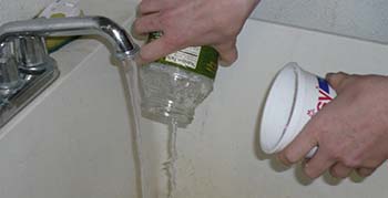 rinsing a glass jar in sink